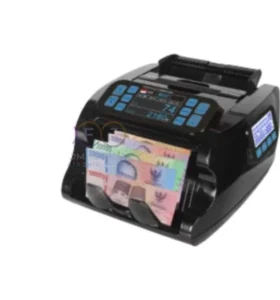 Mesin penghitung uang otomatis berwarna hitam sedang menghitung tumpukan uang kertas Rupiah (Pecahan 100.000, 50.000, dan 20.000). Alat ini memiliki layar digital biru yang menunjukkan jumlah hitungan dan tombol kontrol di bagian atas.